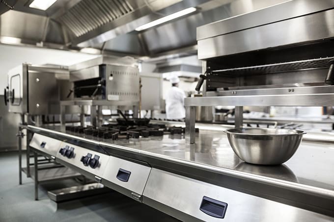 A kitchen with many stainless steel appliances and counters.