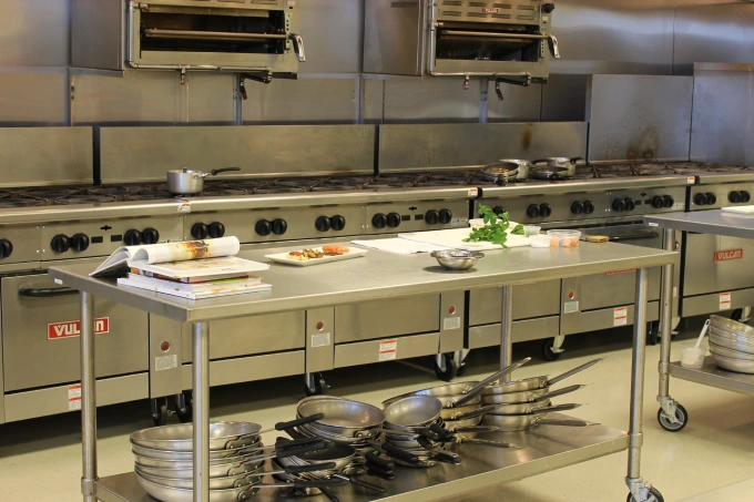 A kitchen with many pots and pans on the counter.