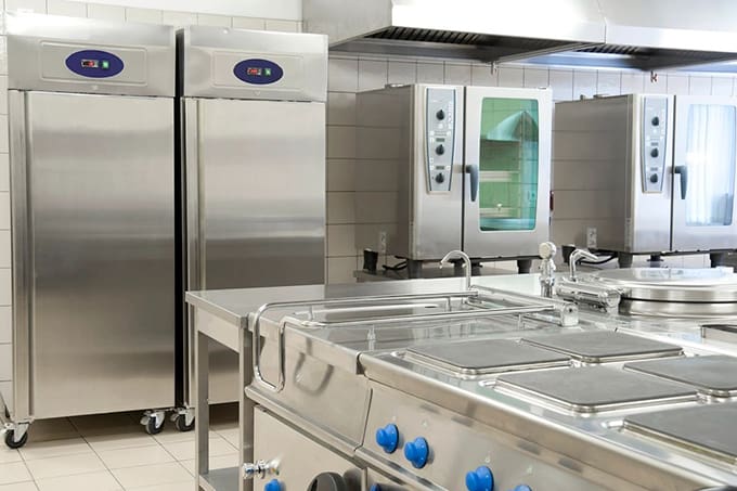 A kitchen with stainless steel appliances and counters.