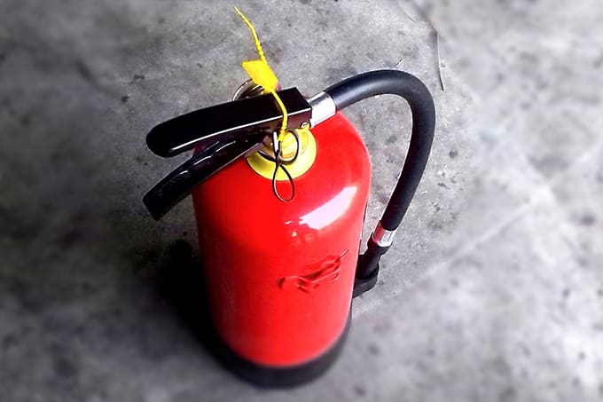 A fire extinguisher sitting on the ground.