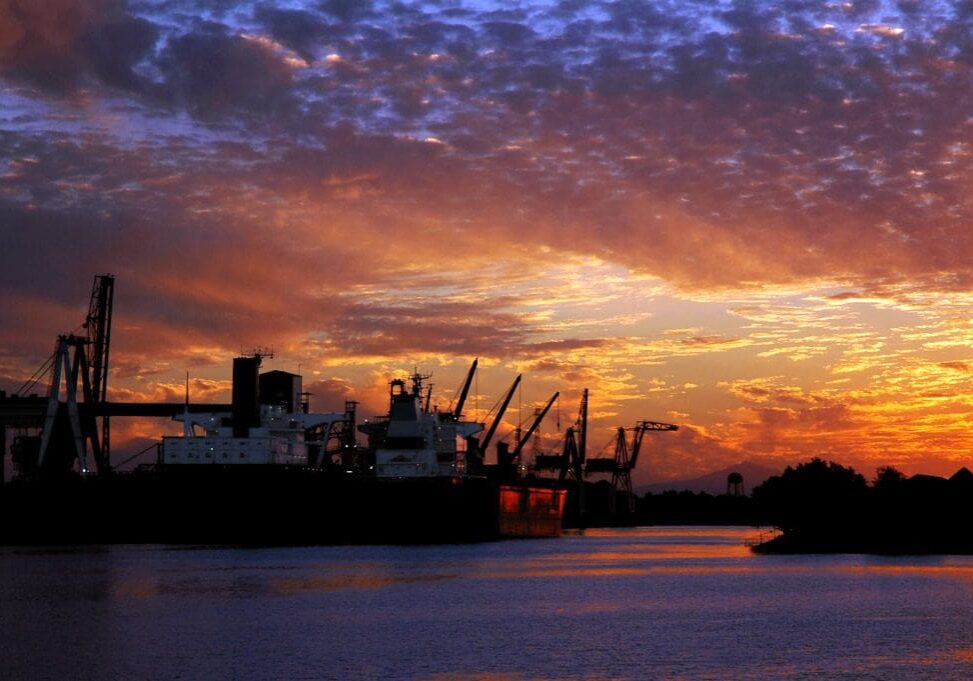 A large ship in the water at sunset.